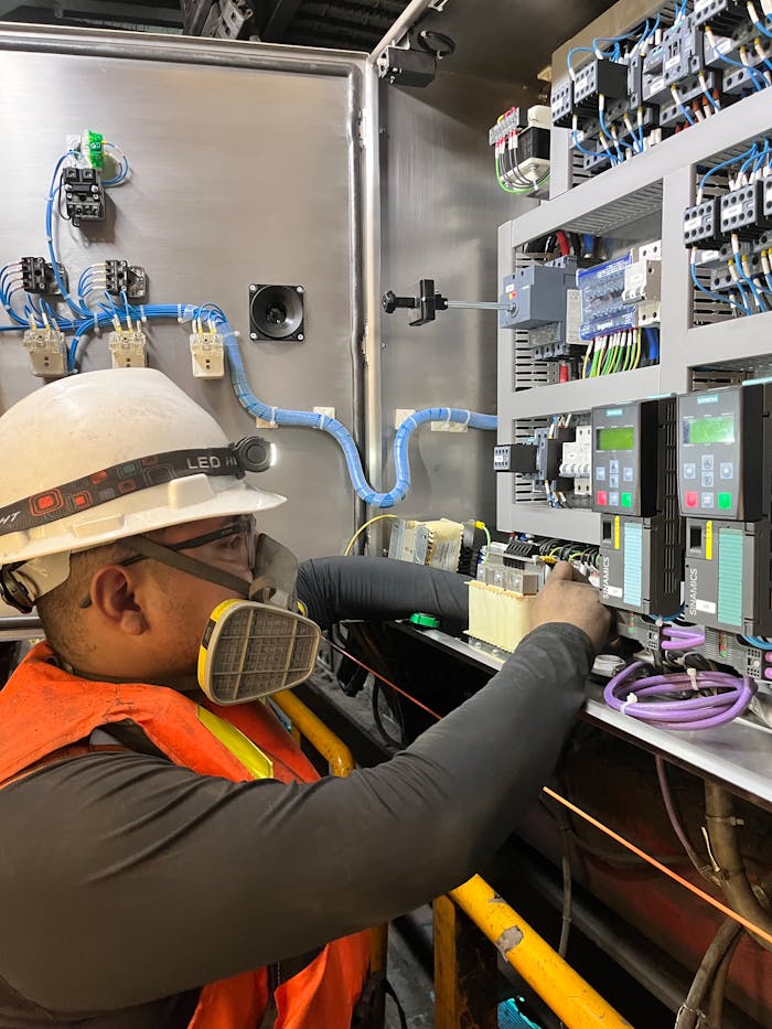 Mastering the First Impression: Your intriguing post title goes here Electrician wearing safety gear adjusting wires on a control panel in Callao, Perú.