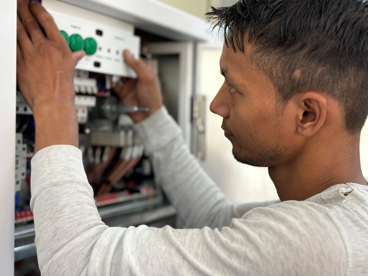 Services Focused electrician adjusting circuit breaker panel. Technology and skill in action.