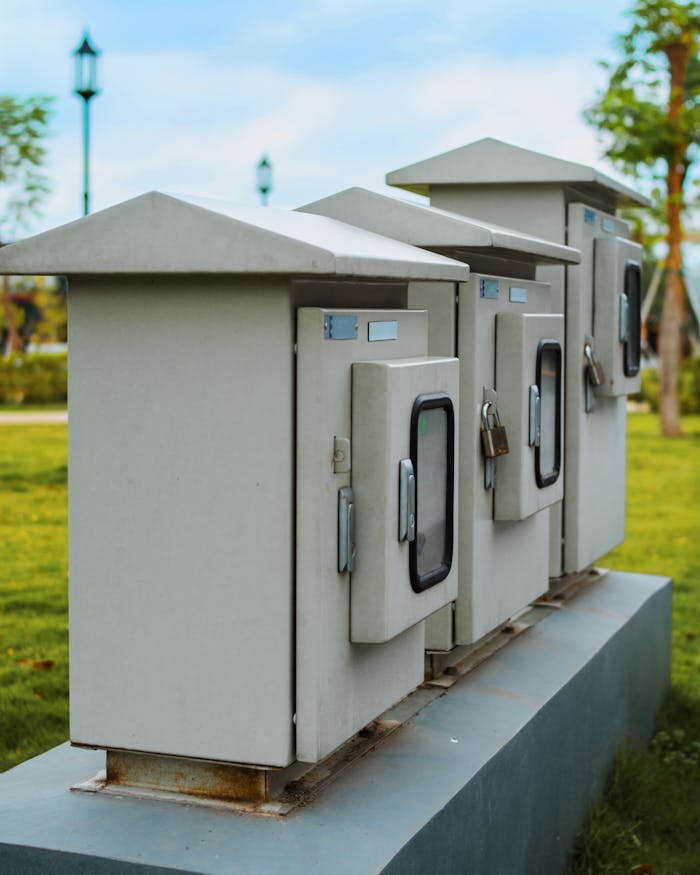 About Close-up of locked electric boxes outdoors, featuring metal cabinets on a platform.